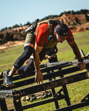 Jake vaulting an obstacle in a plate carrier