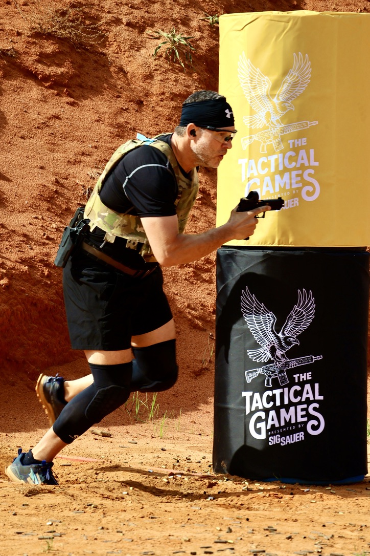 Jake Davidow shooting a pistol around a barricade at the Tactical Games
