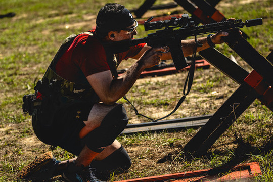 Jake shooting a rifle from a kneeling position