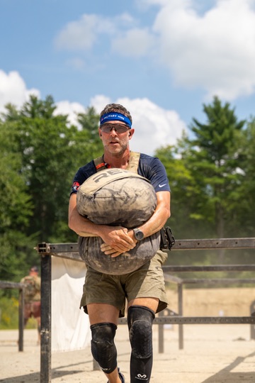 Jake carrying a heavy sandbag during a match